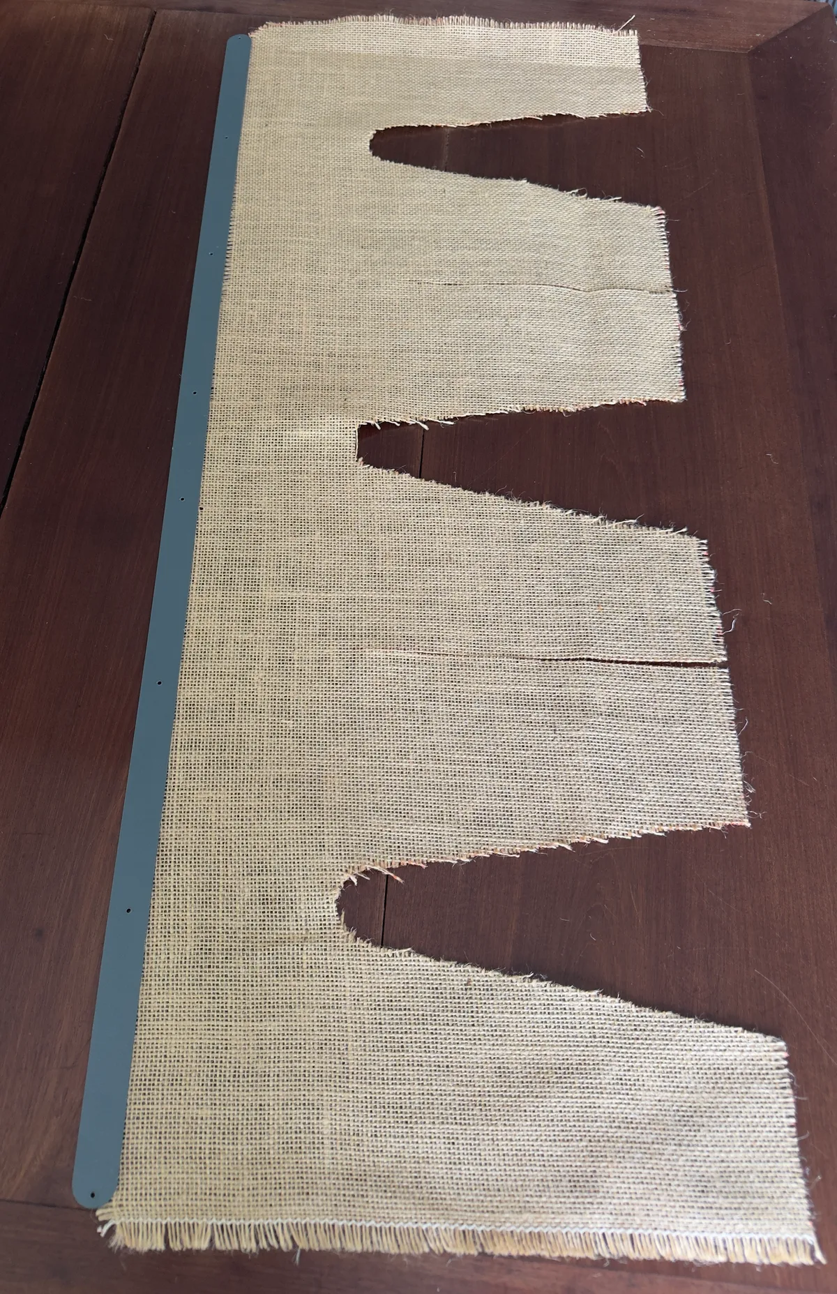 A natural burlap fabric cut to the Gush-Tuss privacy curtain pattern, before installation