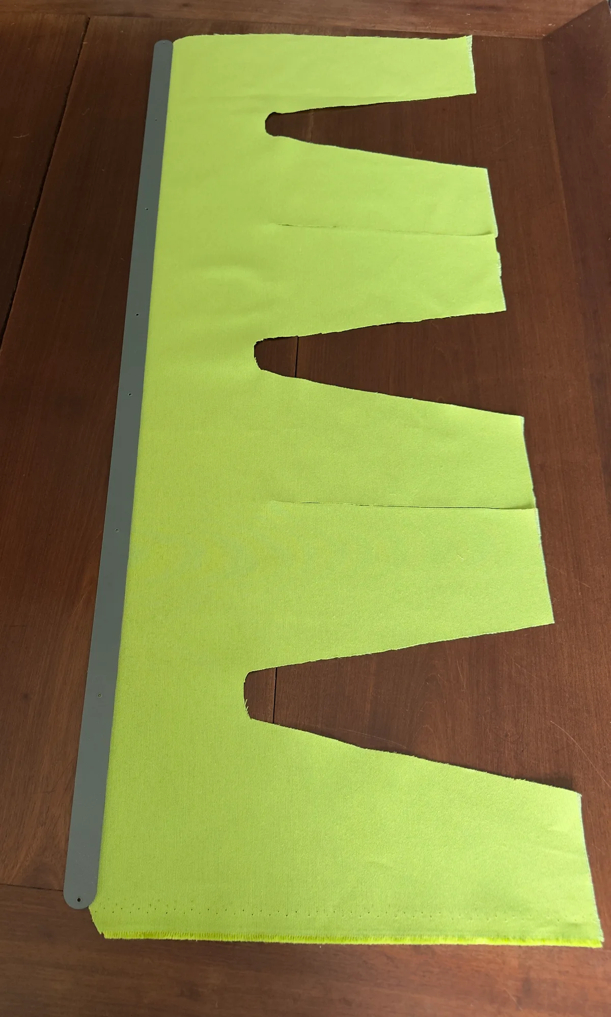 An olive fabric cut to the Gush-Tuss privacy curtain pattern, before installation